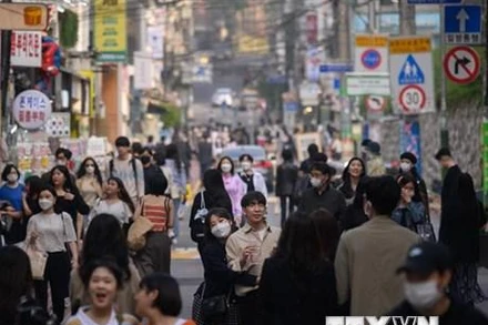 Người dân di chuyển trên đường phố tại Seoul, Hàn Quốc. (Ảnh: AFP/TTXVN)