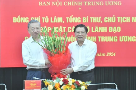 Tổng Bí thư, Chủ tịch nước Tô Lâm nhận hoa chúc mừng tại buổi gặp mặt. Ảnh: Đăng Khoa 