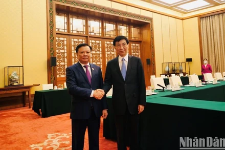 Đồng chí Đinh Tiến Dũng và đồng chí Vương Hộ Ninh. (Ảnh: HỮU HƯNG)