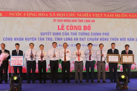 Nguyên Phó Thủ tướng Thường trực Chính phủ Trương Hòa Bình và lãnh đạo tỉnh Long An trao Quyết định của Thủ Tướng Chính phủ công nhận huyện Tân Trụ đạt chuẩn nông thôn mới. 