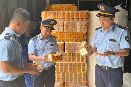 Lực lượng quản lý thị trường kiểm tra số hàng hóa vi phạm bị phát hiện tại cơ sở sản xuất giấy Tuấn Hoa.