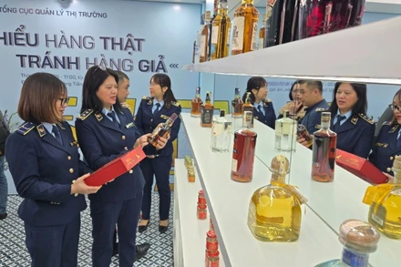 Cán bộ Tổng cục Quản lý thị trường hướng dẫn dấu hiệu nhận diện hàng hóa thật-giả. 