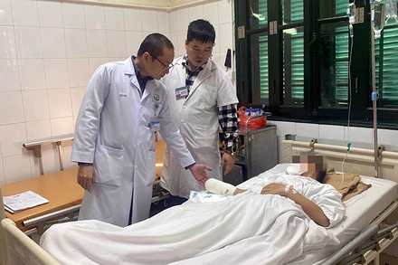 Các y sĩ, bác sĩ của Bệnh viện Việt Đức trao đổi về tình trạng chấn thương do pháo nổ của bệnh nhân. (Ảnh THÁI BÌNH)