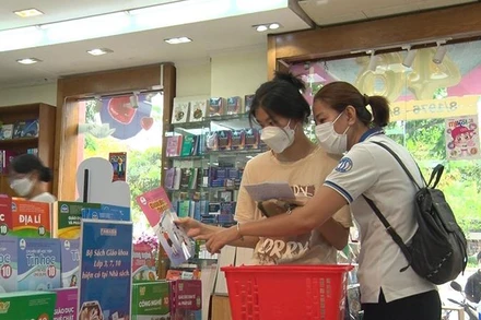 Phụ huynh và học sinh mua sách giáo khoa theo chương trình giáo dục phổ thông năm 2018 tại nhà sách trên địa bàn Thành phố Hồ Chí Minh.