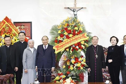 Chủ tịch nước Nguyễn Xuân Phúc tặng hoa chúc mừng Tòa Tổng Giám mục Hà Nội Tổng giáo phận Hà Nội. (Ảnh: Thống Nhất/TTXVN)