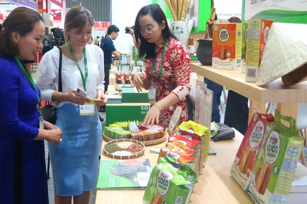 Khách tham quan, tìm hiểu sản phẩm tại một gian hàng thực phẩm tại Triển lãm.