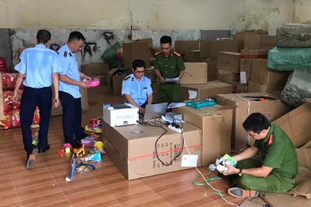 Lực lượng chức năng kiểm tra hàng hóa tại kho chứa hàng của hộ kinh doanh vi phạm.