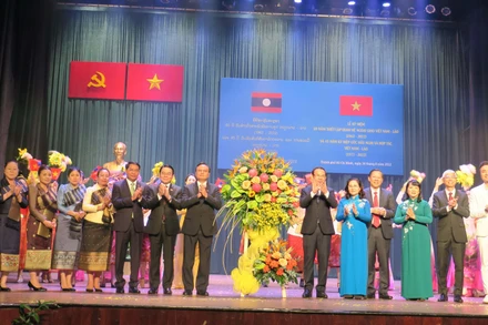 Các đồng chí lãnh đạo Thành phố Hồ Chí Minh và Lào tặng hoa chúc mừng các nghệ sĩ biểu diễn tại Lễ kỷ niệm.