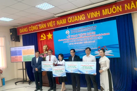 Bà Lê Thị Mỹ Châu (bìa phải), vợ Tiến sĩ Võ Tá Hân, trao sách cho các đơn vị.