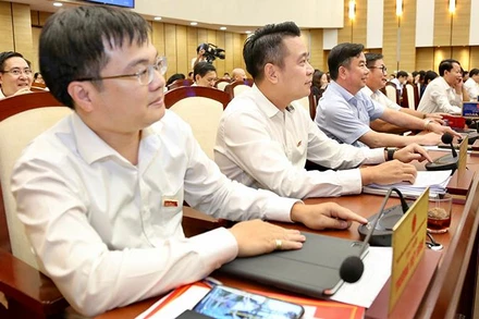 Các đại biểu biểu quyết thông qua nghị quyết. (Ảnh: DUY LINH)