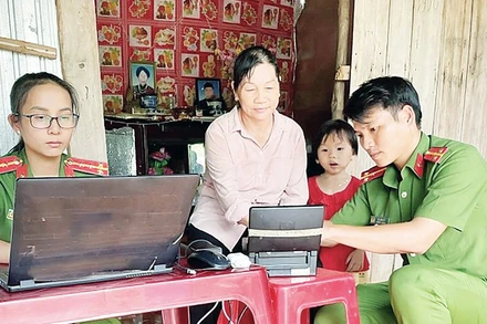 Các chiến sĩ Công an huyện Lộc Ninh đến tận nhà hỗ trợ người dân làm căn cước công dân. (Ảnh: NHẤT SƠN)