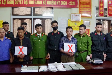 Hai đối tượng Thào Ly Pó và Vàng Mí Co (đánh dấu X) cùng số tang vật 15 bánh heroin bị bắt giữ.