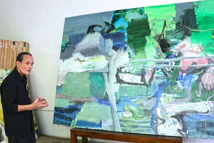 Họa sĩ Trần Hải Minh bên bức tranh “Chuyển động số 3”, đây là một trong những bức tranh có khổ lớn nhất ông từng vẽ.