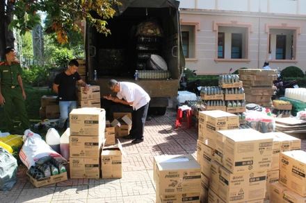 Lực lượng chức năng tổ chức kiểm đếm số lượng tang vật là dầu nhớt giả khi bị bắt.