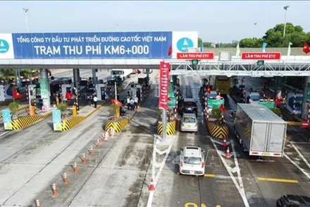 Các phương tiện đã dán thẻ VETC lưu thông qua làn thu phí tự động ETC tại trạm thu phí BOT Nội Bài-Lào Cai. (Ảnh: TTXVN)