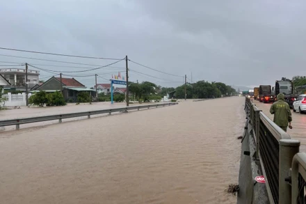 Nước ngập trên tuyến quốc lộ 1 đoạn qua xã an Mỹ, huyện Tuy An (Km1315), lực lượng chức năng điều tiết giao thông bảo đảm an toàn các phương tiện.