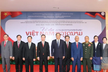 Đồng chí Võ Văn Thưởng (thứ 4 từ trái qua phải), đồng chí Sonsay Siphandone (thứ 5 từ trái qua phải) tại lễ khai mạc triển lãm, chiều 18/7. (Ảnh: XUÂN SƠN)