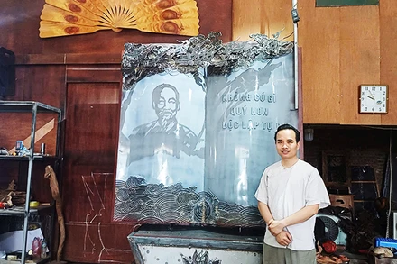 Nghệ nhân Bùi Minh Tự bên tác phẩm “Trang sử vàng”.