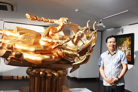 Họa sĩ, nhà điêu khắc Đinh Gia Thắng bên tác phẩm điêu khắc “Cội nguồn hạnh phúc”.