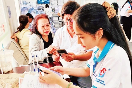 Tình nguyện viên Trung tâm Phát triển khoa học và công nghệ trẻ (Thành đoàn TP Hồ Chí Minh) hỗ trợ người dân làm các thủ tục hành chính.
