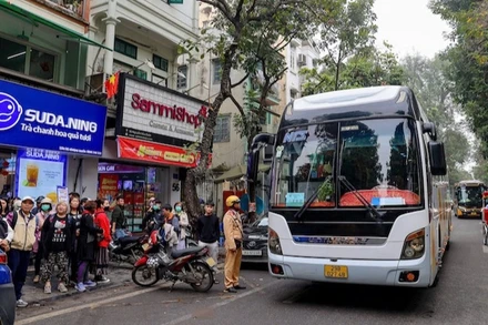 Lực lượng chức năng xử lý xe chở khách vi phạm tại khu vực phố cổ. (Ảnh: CHU DŨNG)