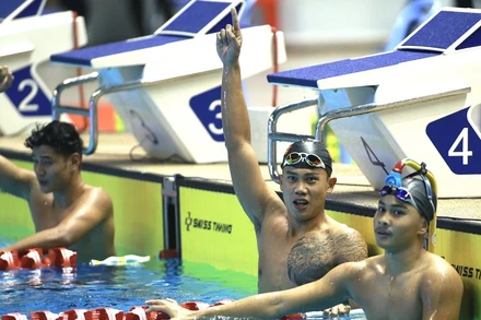 Vũ Đặng Nhật Nam (giữa) giành Huy chương Vàng nội dung lặn vòi hơi chân vịt đôi 400m nam. (Ảnh: TTXVN) 