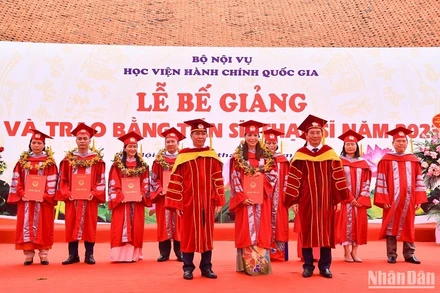 Thứ trưởng Nội vụ, PGS, TS Triệu Văn Cường và Giám đốc Học viện Hành chính Quốc gia, PGS, TS Nguyễn Bá Chiến trao bằng Tiến sĩ cho các nghiên cứu sinh đã hoàn thành đề án năm 2023. (Ảnh: NHẬT QUANG)