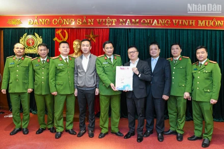 Tổng Biên tập Báo Nhân Dân Lê Quốc Minh (thứ 4 từ phải sang) và các đồng chí trong đoàn công tác trao tặng Báo Nhân Dân Xuân Quý Mão 2023 đến các cán bộ, chiến sĩ Cục Cảnh sát điều tra tội phạm về tham nhũng, kinh tế, buôn lậu. (Ảnh: THÀNH ĐẠT)