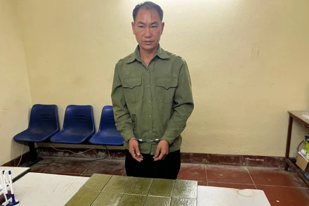 Đối tượng Mùa A Thào cùng 10 bánh heroin tại cơ quan công an.