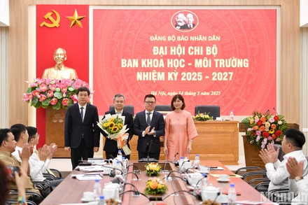 Đồng chí Lê Quốc Minh, Tổng Biên tập, Bí thư Đảng ủy Báo Nhân Dân tặng hoa chúc mừng Chi ủy khóa mới của Chi bộ Ban Khoa học-Môi trường. (Ảnh: THẾ ĐẠI)