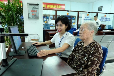 Cán bộ Ủy ban nhân dân quận Bắc Từ Liêm (Hà Nội) hướng dẫn người dân giải quyết thủ tục hành chính. (Ảnh: CÔNG HÙNG)