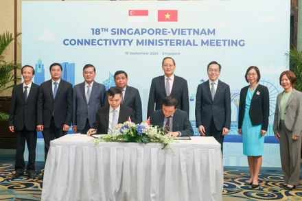 Bộ trưởng Kế hoạch và Đầu tư Nguyễn Chí Dũng và Bộ trưởng Thứ hai Bộ Công nghiệp và Thương mại kiêm Bộ trưởng Nhân lực Singapore, ông Tan See Leng chứng kiến lễ ký kết biên bản ghi nhớ hợp tác giữa các cơ quan của hai bên. (Ảnh: MPI)