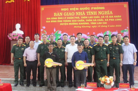 Các đại biểu chụp ảnh lưu niệm cùng 2 gia đình được nhận bàn giao “Nhà tình nghĩa”.