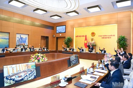 Ủy ban Thường vụ Quốc hội biểu quyết thông qua 2 dự thảo nghị quyết về việc sắp xếp một số đơn vị hành chính của 2 tỉnh Bình Dương và Tiền Giang tại phiên họp chiều 19/3. (Ảnh: DUY LINH)