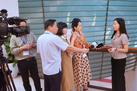 Phóng viên các cơ quan thông tấn, báo chí tác nghiệp tại hành lang Quốc hội trong khuôn khổ Kỳ họp thứ 7. (Ảnh: TRUNG HƯNG) 