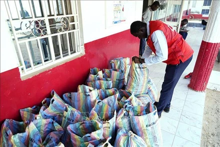 Nhân viên Chữ thập đỏ Gambia kiểm tra số siro ho thu giữ tại Banjul, ngày 6/10/2022. Ảnh: AFP/TTXVN