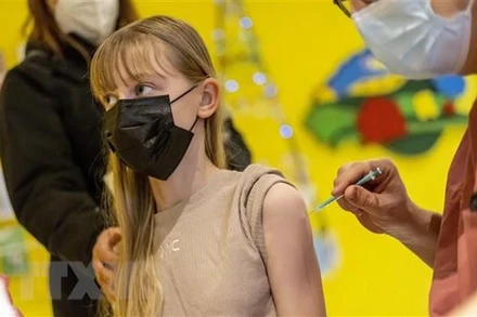 Nhân viên y tế tiêm vaccine ngừa Covid-19 cho người dân tại Berlin, Đức. (Ảnh: AFP/TTXVN)