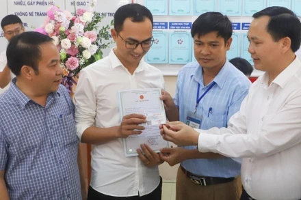 Trao giấy khai sinh và thẻ bảo hiểm y tế theo dịch vụ công liên thông giữa cơ sở dữ liệu về hộ tịch và bảo hiểm. (Ảnh minh họa: TTXVN)