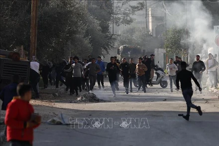 Người Palestine trong cuộc đụng độ với các lực lượng Israel tại Jenin, Bờ Tây ngày 26/1/2023. (Ảnh: THX/TTXVN)