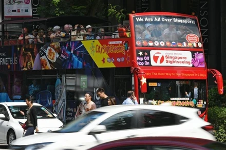 Xe buýt chở khách du lịch trên đường phố Singapore. (Ảnh: Xinhua)