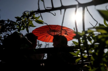 Người dân dùng ô che nắng trong đợt nắng nóng bất thường giữa mùa đông ở Santiago, Chile, ngày 3/8/2023. (Ảnh: Reuters)