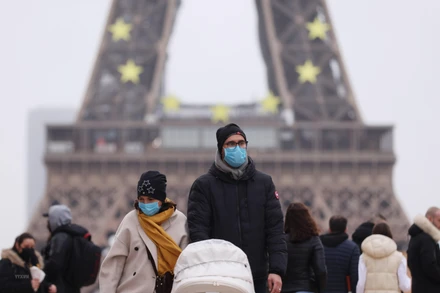 Người dân đeo khẩu trang phòng Covid-19 khi đi trên đường phố Paris, Pháp, ngày 29/12/2021. (Ảnh: THX/TTXVN)
