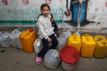 Trẻ em Palestine chờ lấy nước bên trong một trại di tản ở Gaza, ngày 6/4/2025. (Ảnh: Xinhua) 