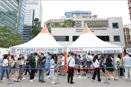 Người dân chờ xét nghiệm Covid-19 tại điểm xét nghiệm ở Seoul, Hàn Quốc, ngày 12/7/2022. (Ảnh: YONHAP/TTXVN)