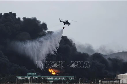 Trực thăng phun nước dập lửa tại hiện trường vụ cháy kho chứa nhiên liệu ở Matanzas, Cuba ngày 8/8/2022. (Ảnh: AFP/TTXVN)