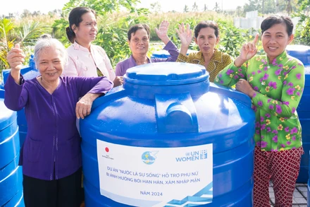 Phụ nữ Cà Mau nhận bồn chứa nước sinh hoạt trong khuôn khổ dự án “Nước là sự sống”. 