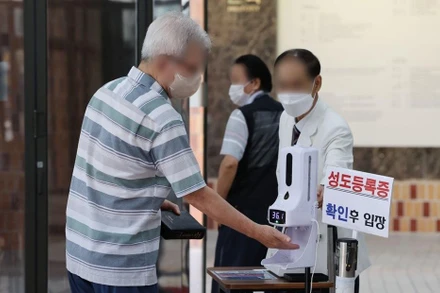 Kiểm tra thân nhiệt trước khi vào nhà thờ ở Seoul, Hàn Quốc, ngày 17/7/2022. (Ảnh: Yonhap)