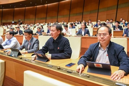 Các đại biểu bấm nút thông qua Nghị quyết về thí điểm xử lý vật chứng, tài sản trong quá trình điều tra, truy tố, xét xử một số vụ việc, vụ án hình sự. (Ảnh: DUY LINH) 