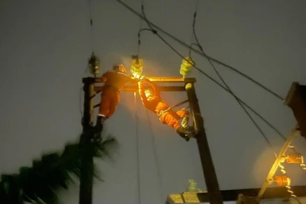 Tại Ninh Bình, thợ điện cheo leo trên cột cao để thực hiện nhiệm vụ “cứu điện” trong đêm 7/9 dưới ảnh hưởng của bão số 3. (Ảnh: EVN)