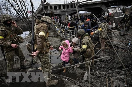 Người dân sơ tán khỏi thành phố Irpin, tây bắc thủ đô Kiev, Ukraine. (Ảnh: AFP/TTXVN)